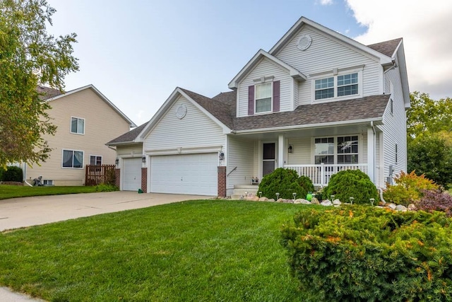 view of front of property with a porch, a front yard, and a garage