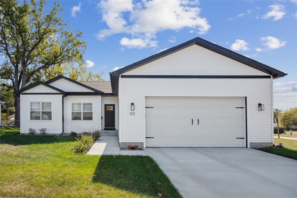 single story home featuring a garage and a front lawn