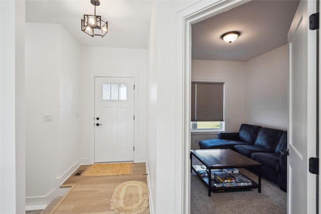 entryway with a textured ceiling and a chandelier