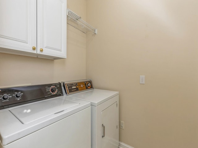 washroom with cabinets and washing machine and clothes dryer