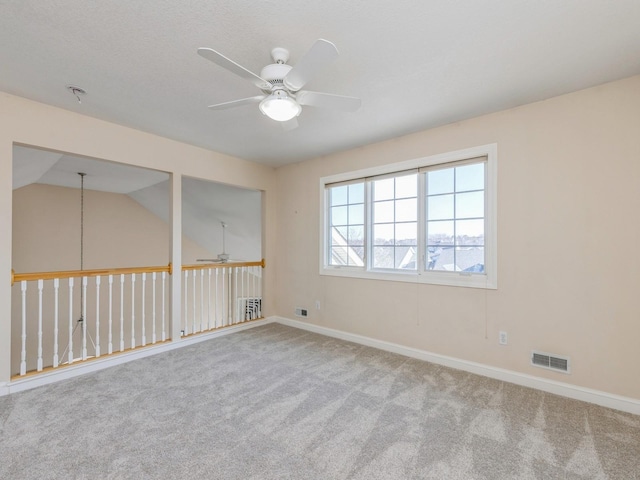 carpeted empty room featuring ceiling fan and vaulted ceiling