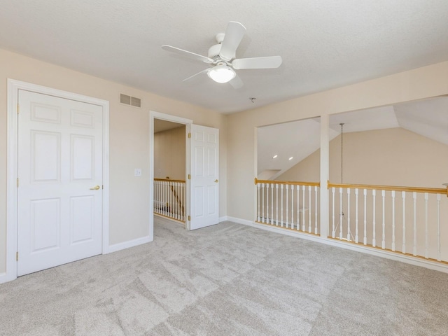 interior space featuring ceiling fan, light carpet, and vaulted ceiling