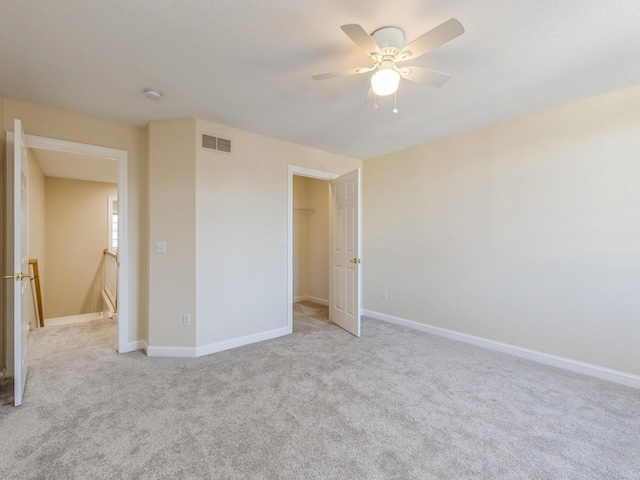 unfurnished bedroom featuring ceiling fan, a closet, and light colored carpet