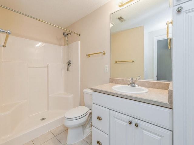 bathroom featuring tile patterned floors, vanity, toilet, and a shower