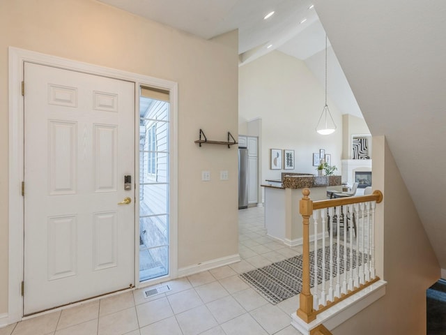 foyer entrance featuring light tile patterned floors and lofted ceiling