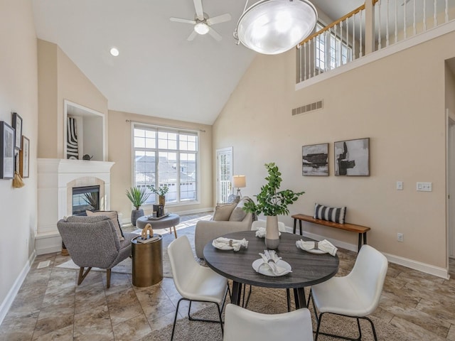 dining area with ceiling fan and high vaulted ceiling