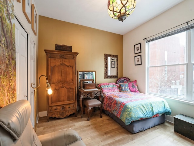 bedroom with multiple windows and light hardwood / wood-style flooring