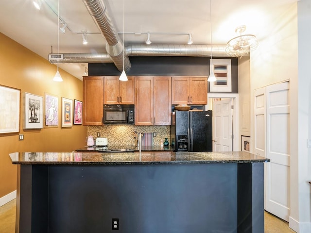 kitchen with backsplash, dark stone counters, black appliances, pendant lighting, and a center island