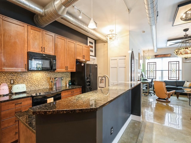 kitchen featuring hanging light fixtures, tasteful backsplash, an island with sink, dark stone counters, and black appliances