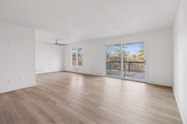 empty room featuring ceiling fan, light hardwood / wood-style floors, and a textured ceiling