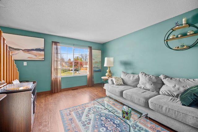 living room with wood-type flooring and a textured ceiling