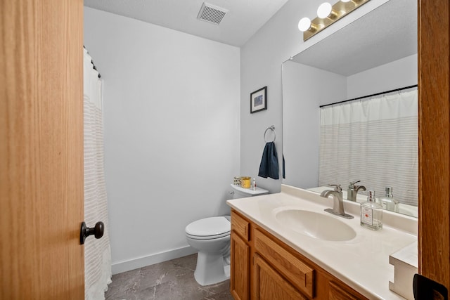 bathroom with vanity, a textured ceiling, and toilet