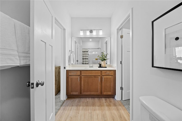 bathroom with vanity, toilet, wood-type flooring, and walk in shower