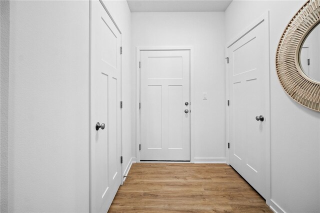 entryway featuring baseboards and light wood-type flooring