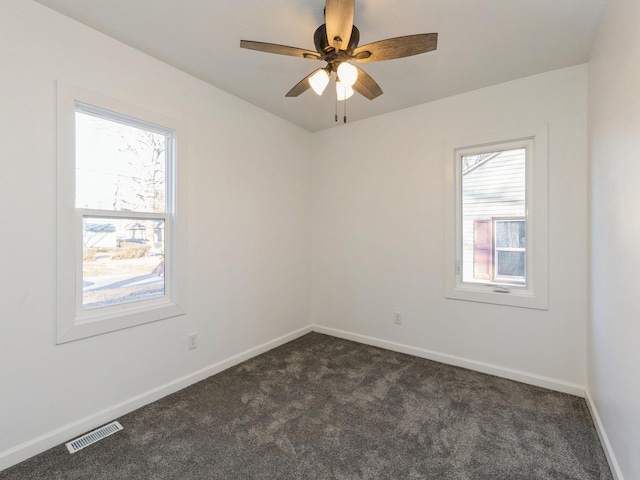 carpeted spare room featuring ceiling fan