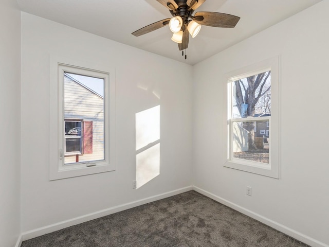 spare room with dark colored carpet and ceiling fan