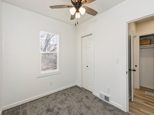 unfurnished bedroom featuring carpet floors, ceiling fan, and a closet