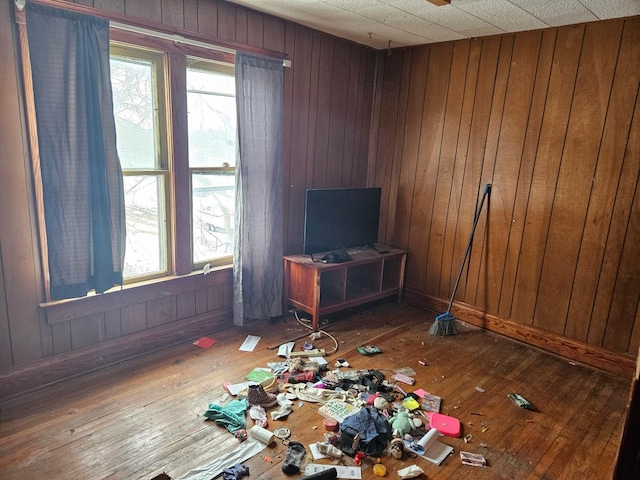 unfurnished living room featuring hardwood / wood-style floors and wood walls