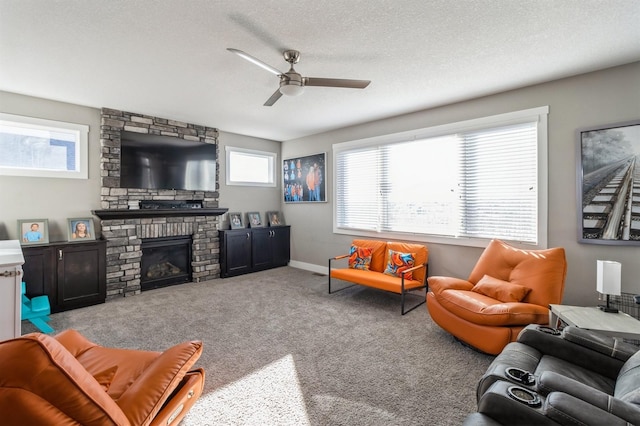 carpeted living room featuring ceiling fan, a textured ceiling, and a brick fireplace