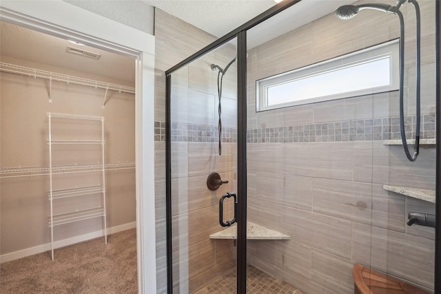 bathroom featuring visible vents, a shower stall, and baseboards