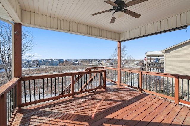 wooden terrace featuring ceiling fan, a residential view, and stairway