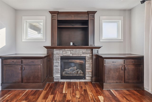 unfurnished living room featuring a fireplace and dark wood-type flooring