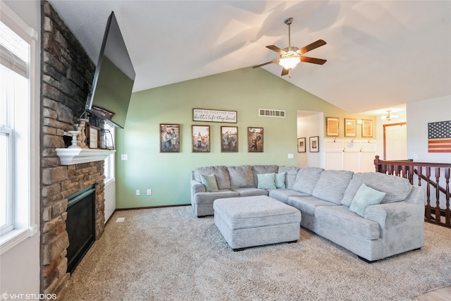 carpeted living room with ceiling fan, a fireplace, and vaulted ceiling