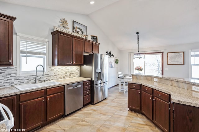 kitchen featuring sink, vaulted ceiling, decorative backsplash, decorative light fixtures, and stainless steel appliances