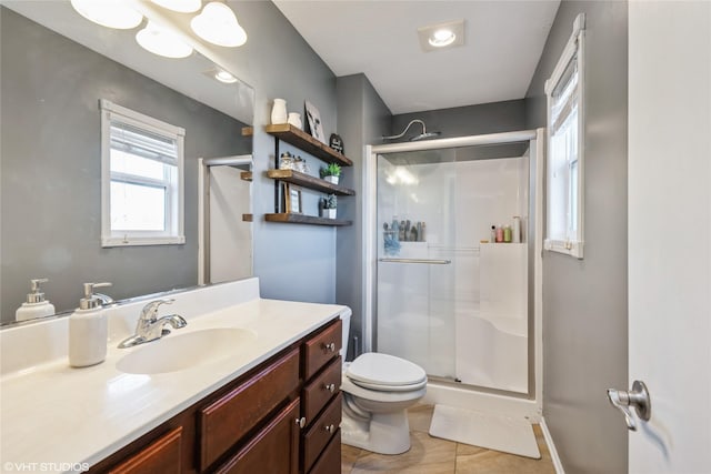 bathroom featuring tile patterned floors, toilet, vanity, and walk in shower