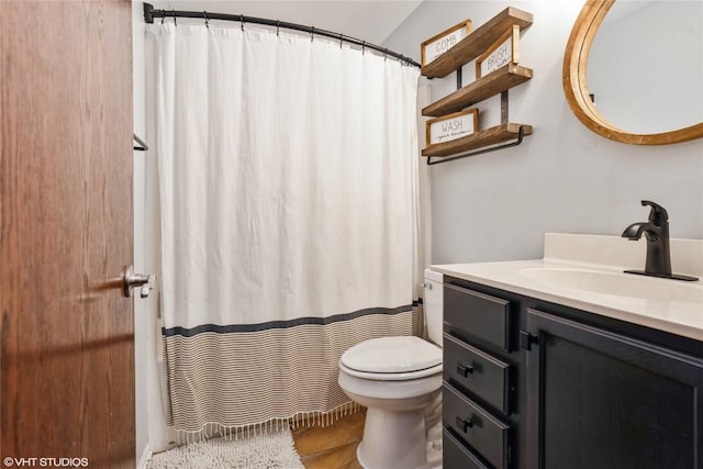 bathroom with hardwood / wood-style flooring, vanity, and toilet