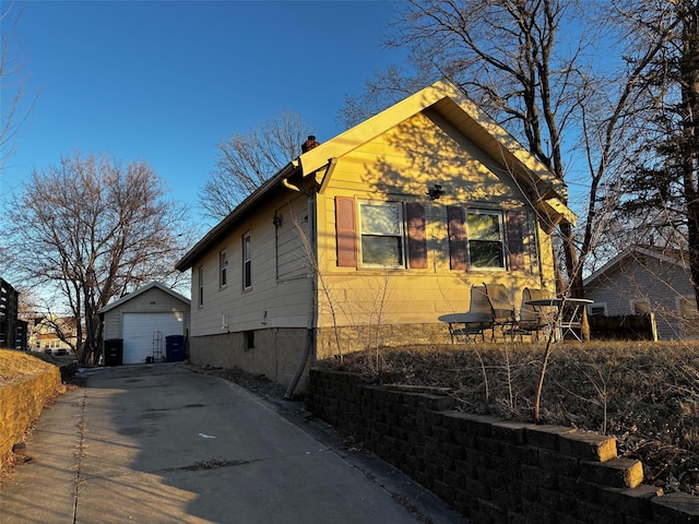 view of property exterior with a garage and an outdoor structure