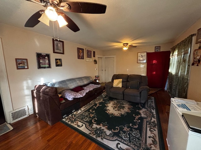 living room featuring a textured ceiling, dark hardwood / wood-style flooring, and ceiling fan