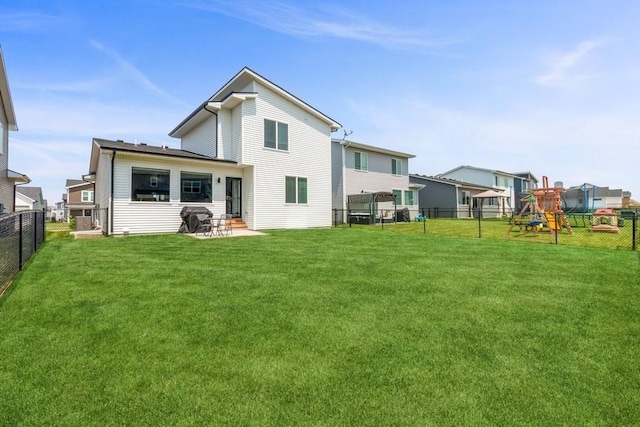 back of property featuring a yard, a playground, and a patio