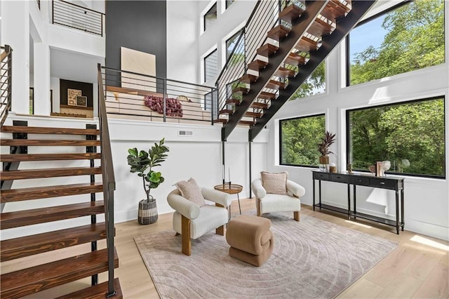 interior space with a towering ceiling, plenty of natural light, and wood-type flooring