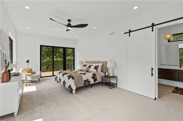 bedroom with a barn door, light carpet, access to exterior, and ceiling fan