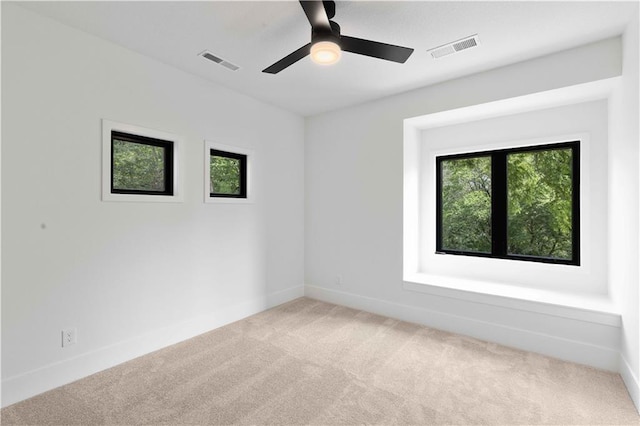 carpeted empty room featuring plenty of natural light and ceiling fan