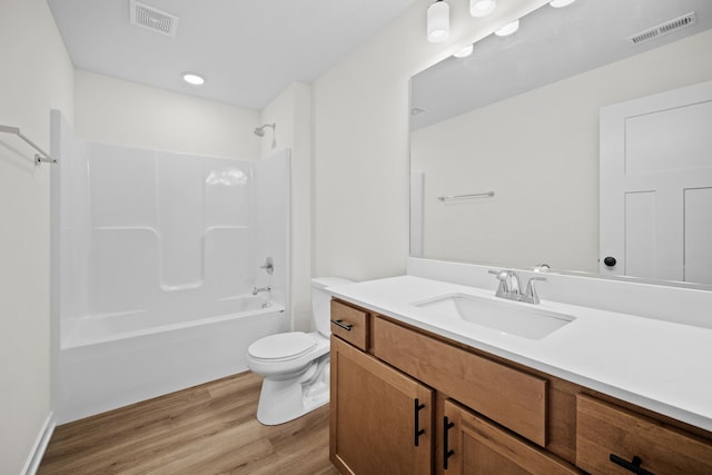 full bathroom with vanity, hardwood / wood-style floors,  shower combination, and toilet