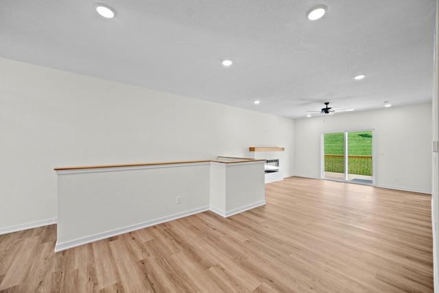 empty room with ceiling fan and light hardwood / wood-style flooring