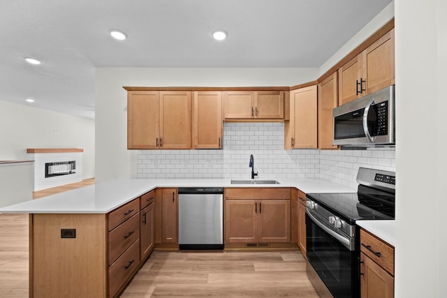 kitchen featuring decorative backsplash, sink, kitchen peninsula, and stainless steel appliances