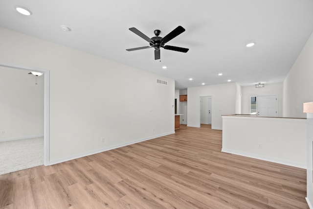 unfurnished living room with ceiling fan and light wood-type flooring