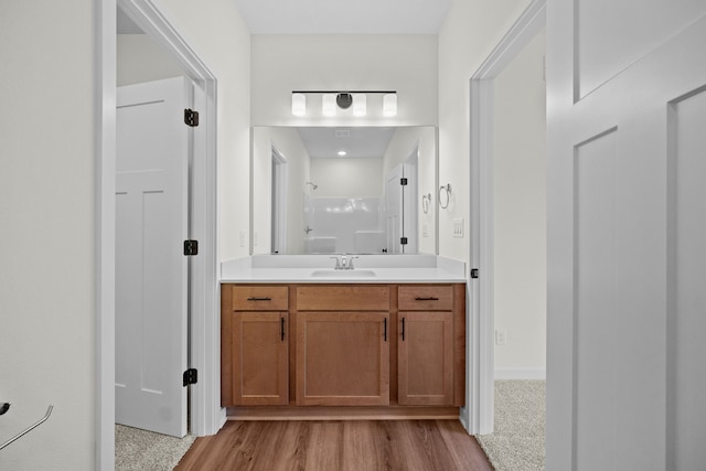 bathroom with a shower, vanity, and hardwood / wood-style flooring