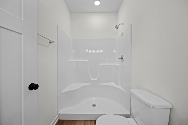 bathroom with walk in shower, hardwood / wood-style flooring, and toilet