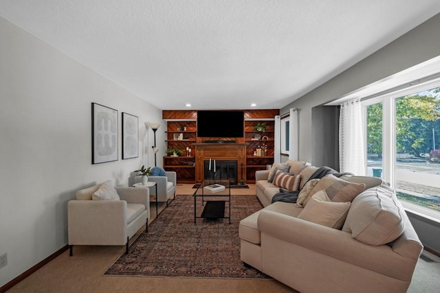 living room with carpet flooring, built in features, and a textured ceiling