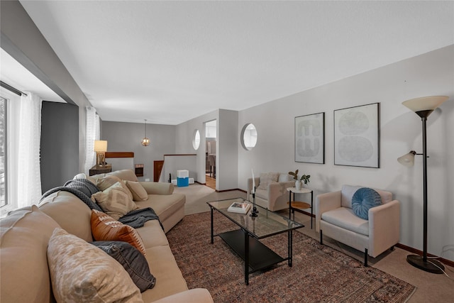 carpeted living room with a healthy amount of sunlight and a chandelier