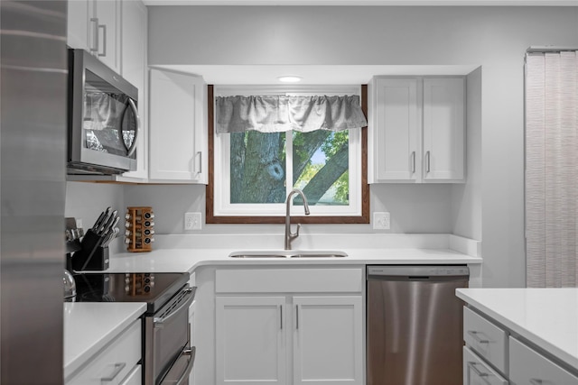 kitchen featuring white cabinets, appliances with stainless steel finishes, and sink