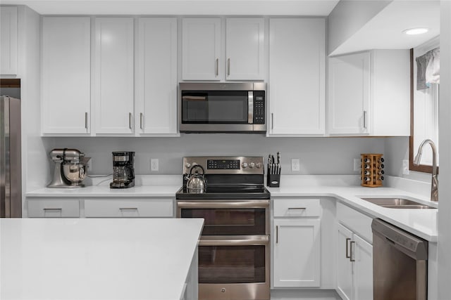 kitchen with sink, white cabinets, and appliances with stainless steel finishes