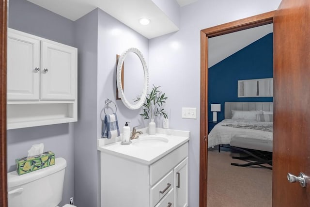 bathroom featuring vanity, lofted ceiling, and toilet