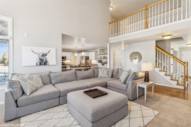 carpeted living room featuring a high ceiling