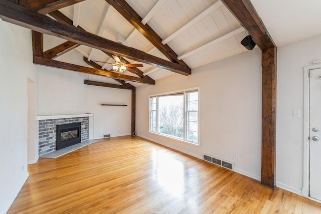 unfurnished living room with vaulted ceiling with beams, light hardwood / wood-style flooring, a brick fireplace, and ceiling fan