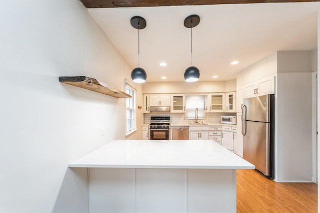 kitchen featuring white cabinets, sink, kitchen peninsula, and stainless steel appliances